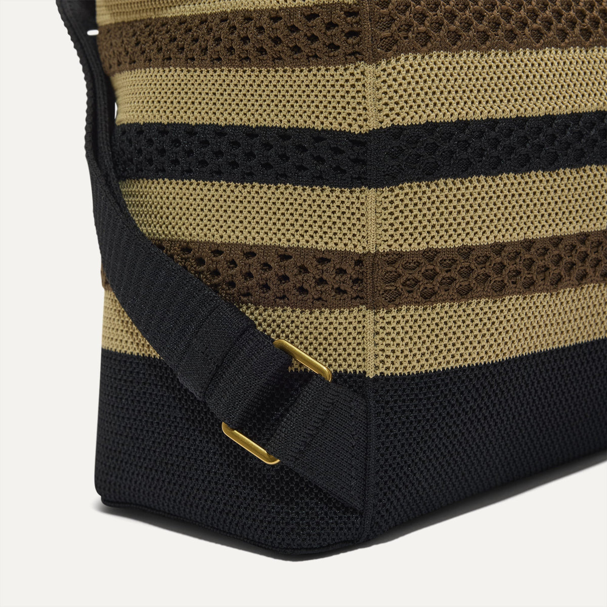 A close up of the adjustable strap on The Cinch Backpack in Mocha Stripe Crochet.