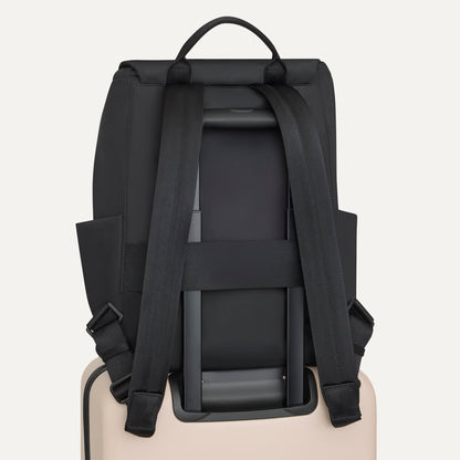 The Travel Cinch Backpack in Ink shown from the back, shown attached to a rolling suitcase using the wrap-around band.